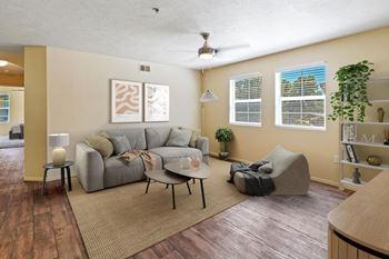 A living room with a grey couch and a rug. at Bluffs Apartments, Bluffdale, 84065